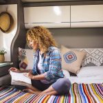 Woman reading in RV with RV Foldable Shelf